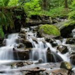 A breathtaking vista of cascading waterfalls passing through the rugged terrains.