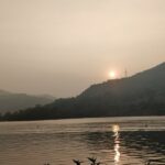 A sunset picture of Lavasa's scenic lake surrounded by lush hills and mountains.