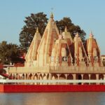 A scenic glimpse of a pristine temple in Haryana surrounded by shimmering blue waters.