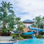 Vew of a swimming pool ans slides inside the Fun Gaon water park surrounded by greenery